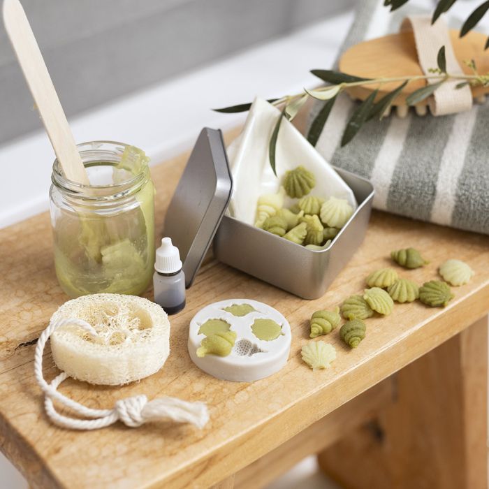 Reisebeholder med små olivenoljesåper og luffasvamp