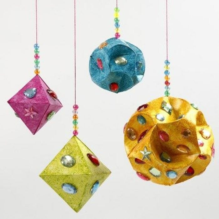 Rhinsten og glittermaling på prismer og kuler av papir