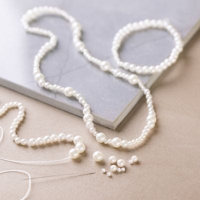 Halskjede og armbånd med hvite perlemorperler