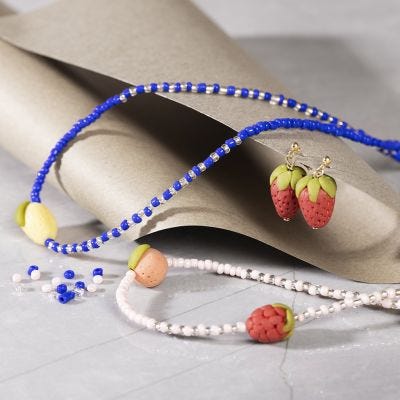 Halskjeder og øreringer med fruktperler i smykkeleire