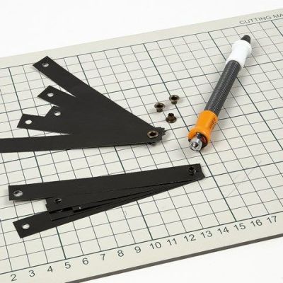 Oppheng av svarte lakkstrimler i snørering med lærsnøre