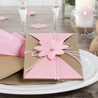 Invitasjon pakket inn og lukket med snor og utstanset blomst
