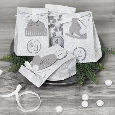 Adventsgaver pyntet med papirklipp og pomponer