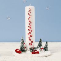 Dekorasjon med kalenderlys omgitt av mini julelandskap 