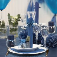 Borddekking og bordpynt i mørk blå med papirblomster, ballonger, serviett brettet som tårn og bordkort